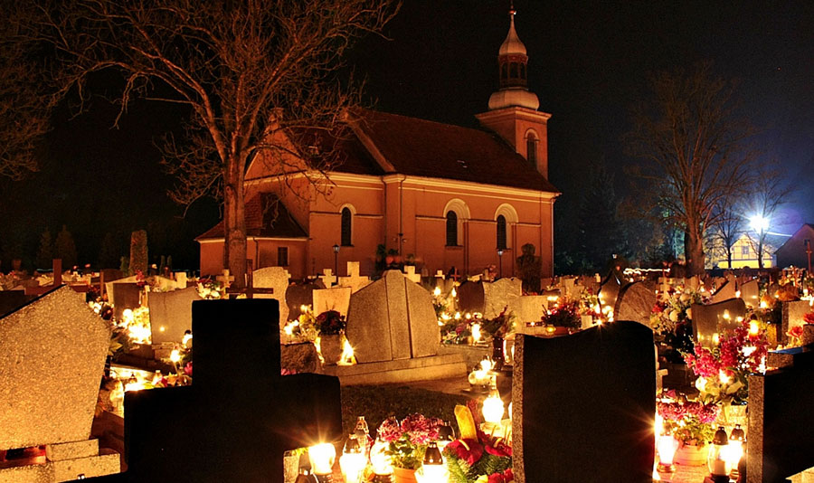 Candles and flowers fill a church graveyard for All Saints Day in Iłówiec, Poland.